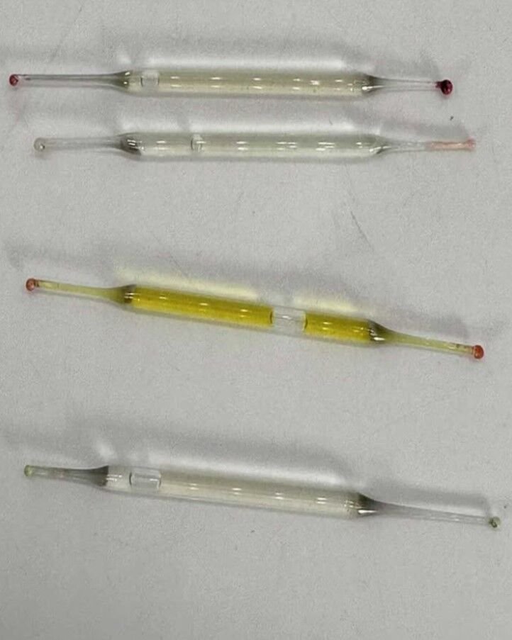 What’s this? Found under a bathroom vanity during remodeling—small glass tubes, 2 inches long, filled with liquid. Any ideas?